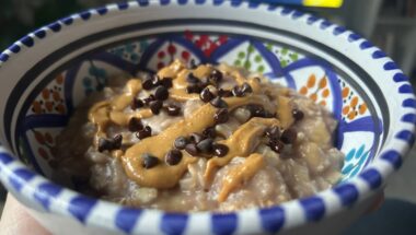 Porridge di avena caldo vegano con burro di arachidi e gocce di cioccolato