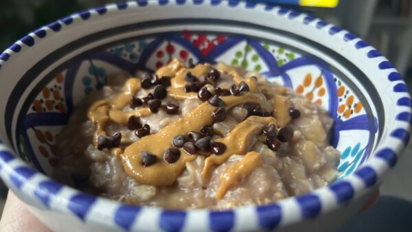Porridge di avena caldo vegano con burro di arachidi e gocce di cioccolato