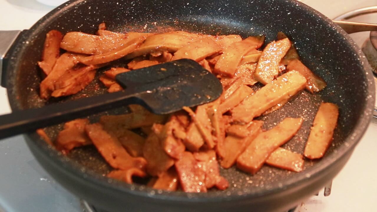 Straccetti di seitan rosolati mescolati con la spatola